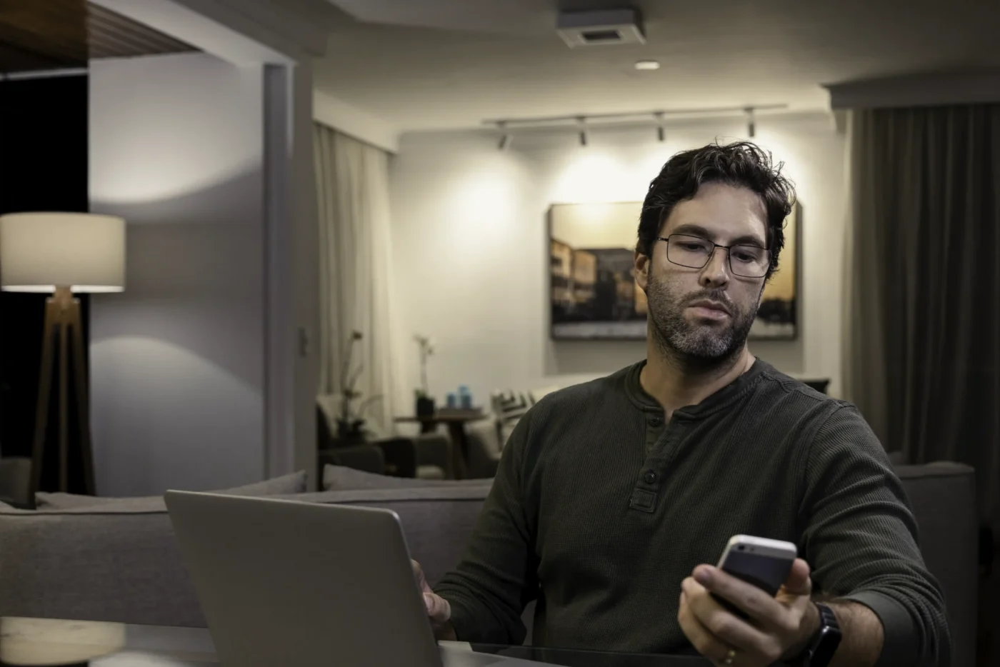 dark hair man ny homeowner is looking at his phone and reading notification